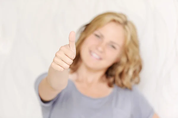 Junge lächelnde Frau zeigt Daumen hoch — Stockfoto