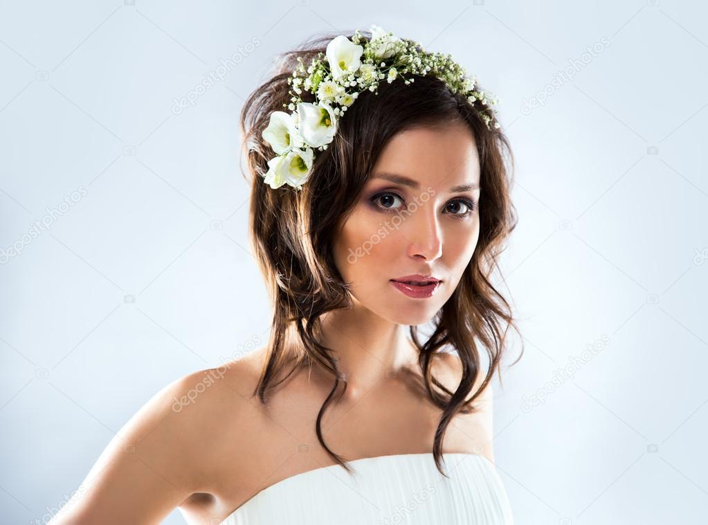 Beautiful bride wearing white wedding dress with flowers on her head