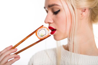 Beyaz saçlı kız suşi izole bir çubukla yemek