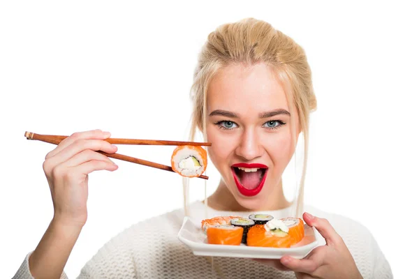 Vithårig flicka äta sushi med en pinnar, isolerade — Stockfoto