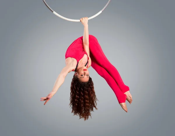 Z tworzywa sztucznego piękna dziewczyna gimnastyczka na akrobacji cyrkowych pierścień w kolorze kolorze. Antenowe pierścień. — Zdjęcie stockowe