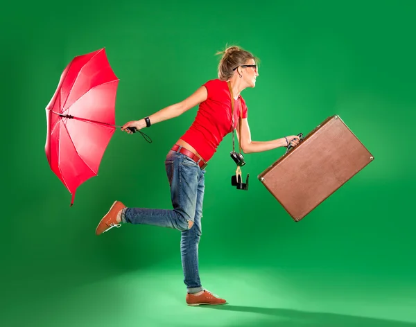 Young woman tourist with umbrella and a suitcase — Stock Photo, Image