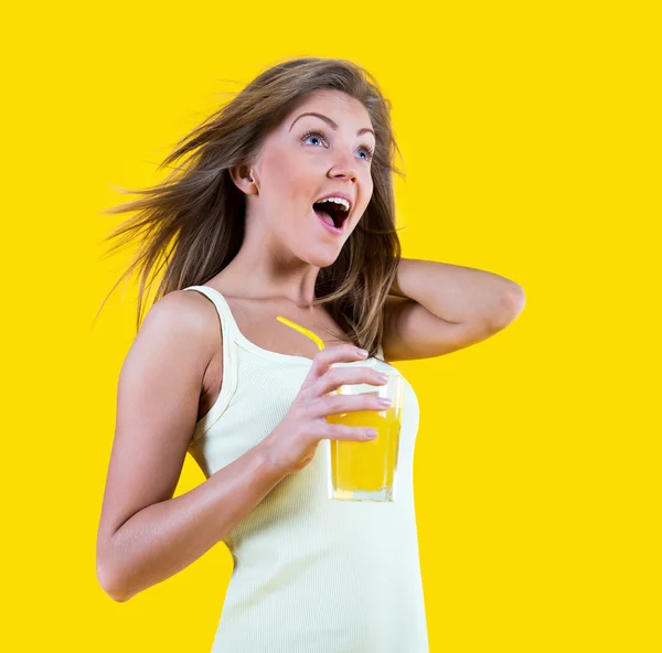 Teenager Mädchen trinken Orangensaft auf gelbem Hintergrund — Stockfoto