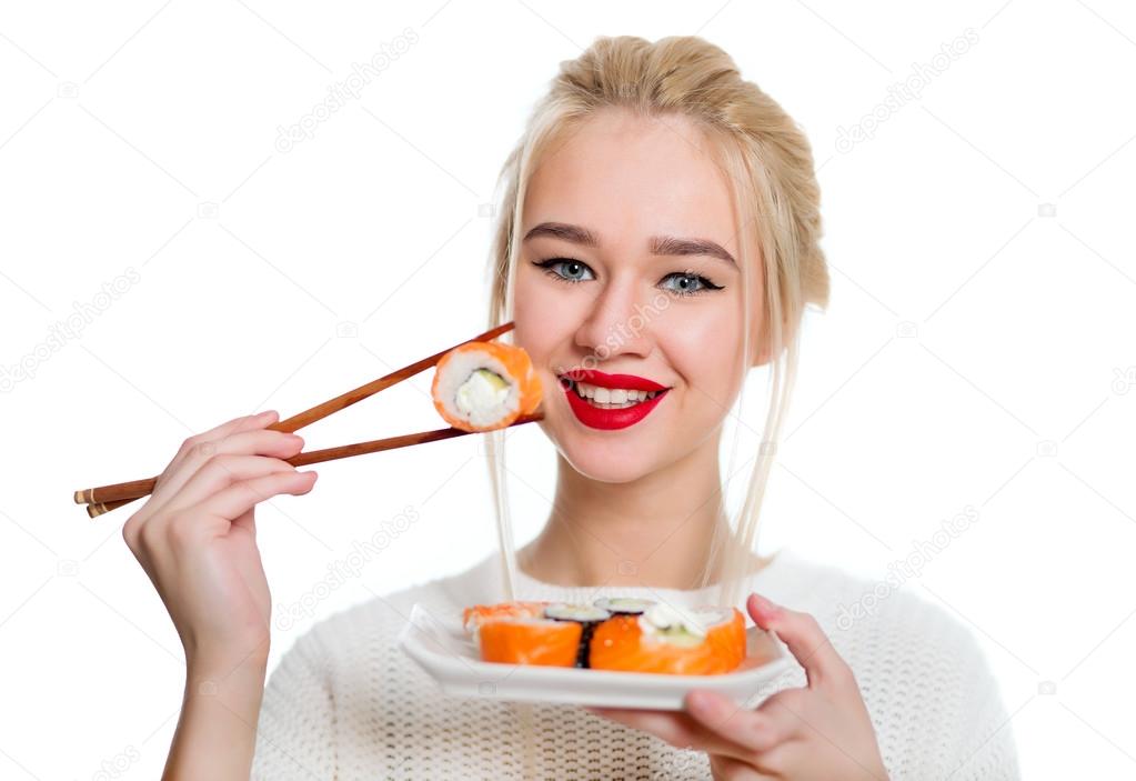 Beautiful woman holding sushi with a chopsticks, isolated