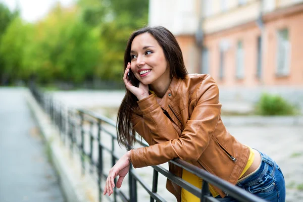 Portrait of a beautiful young woman talking on the phone in the — Stock Photo, Image