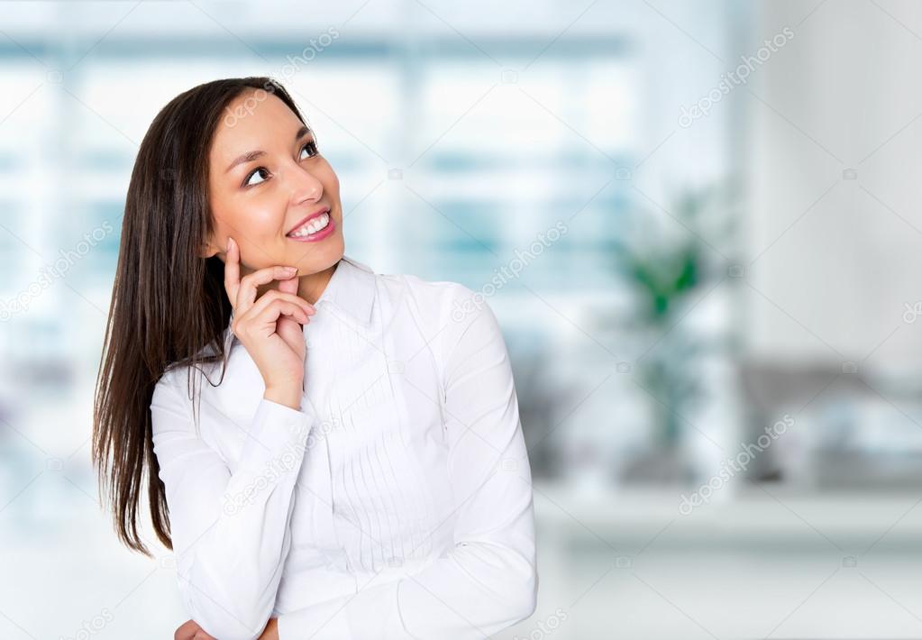 Smiling businesswoman in formalwear sitting at workplace