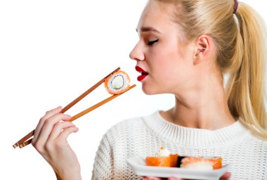 Beyaz izole bir çubuk ile suşi tutan genç kadın