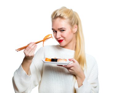 Beyaz izole bir çubuk ile suşi tutan genç kadın