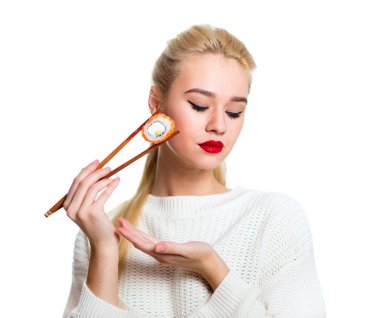 Beyaz izole bir çubuk ile suşi tutan genç kadın