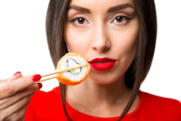 Jeune femme tenant des sushis avec des baguettes, isolée sur du blanc — Photo