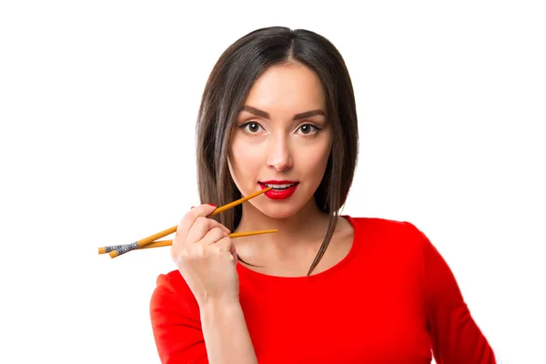 Mujer joven sosteniendo sushi con palillos, aislado en blanco — Foto de Stock