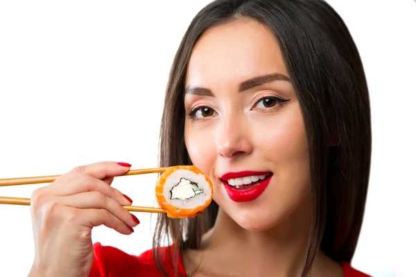 Młoda kobieta trzymając sushi z pałeczkami, na białym tle — Zdjęcie stockowe