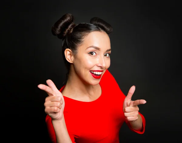 Portrait of young excited woman pointing forefingers over black — Stock Photo, Image