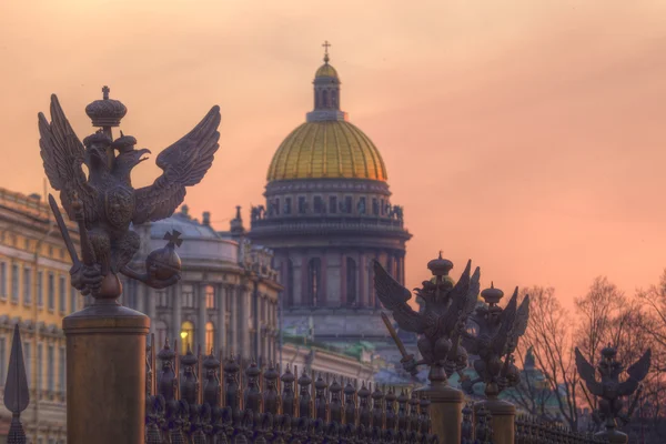 Russia. San Pietroburgo. Piazza del Palazzo. Aquile - elementi decorativi del reticolo della Colonna Alexander sullo sfondo della Cattedrale di Sant'Isacco — Foto Stock