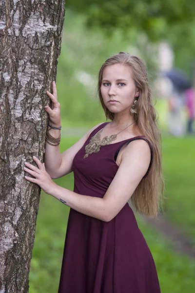 Chica de pie cerca del árbol en el parque — Foto de Stock