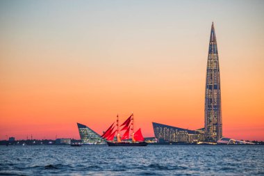 Russia. St. Petersburg. Sailboat with scarlet sails in the Gulf of Finland against the background of Lakhta Center clipart