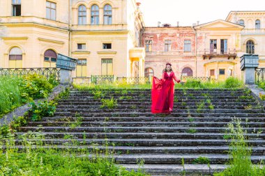 Kırmızı elbiseli kız merdivenlerden iniyor.