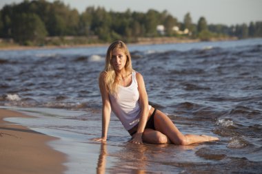 genç kız plajda su oturan beyaz tişört