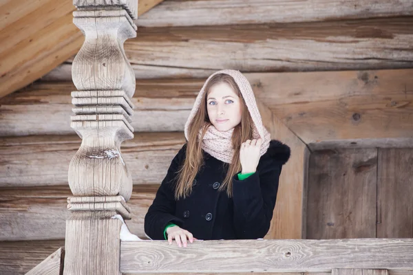 Dziewczyna w czarnym płaszczu stojący na ganku przy domku rosyjski — Zdjęcie stockowe
