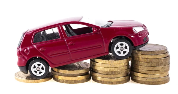 Steigende Preise für Autos. Spielzeugauto auf einem Hintergrund aus Stapeln von Münzen — Stockfoto