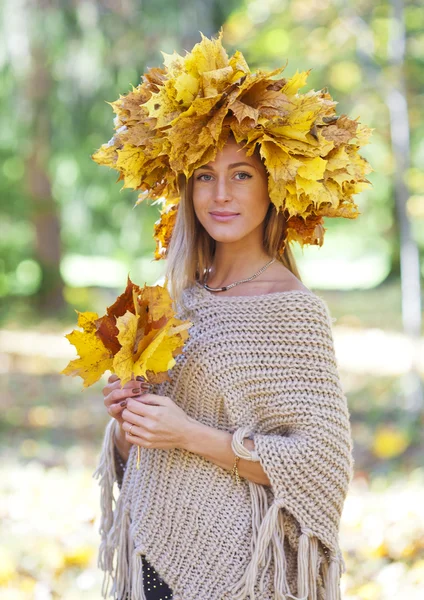Kız sonbahar. Başlarını ve akçaağaç yaprakları bir çelenk ile genç kız elinde bırakır — Stok fotoğraf