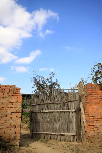 Cerca velha com parede de tijolo — Fotografia de Stock