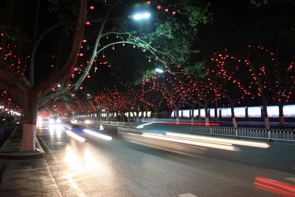 Veicoli e luce, alberi nella città moderna, nella notte — Foto Stock