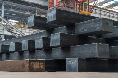 Çelik fabrikasının üretim atölyesine istiflenmiş çelik külçelerin yakın plan fotoğrafını çek.