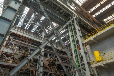 Çelik fabrikasının üretim atölyesindeki çelik yapı desteğinin yakın plan fotoğrafı.