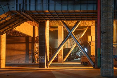 Çelik fabrikasının üretim atölyesinde erimiş çelikle aydınlatılan çelik yapısının yakın plan fotoğrafı.