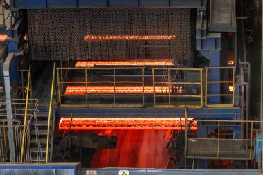 Çelik fabrikasının üretim atölyesindeki sıcak ve kırmızı çelik külçelerin yakın çekim fotoğrafı