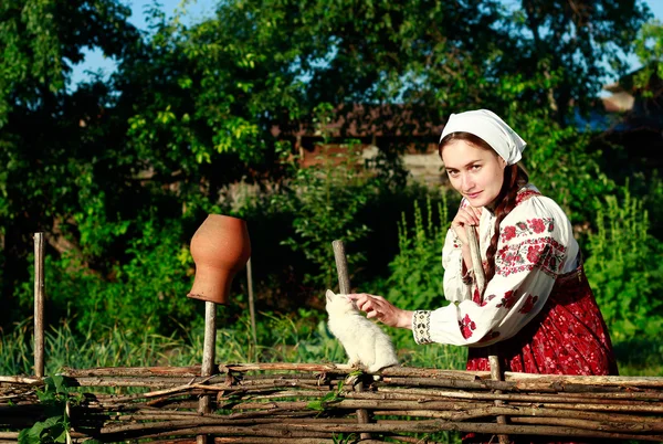 在篱笆的民族服装的俄罗斯姑娘 — 图库照片