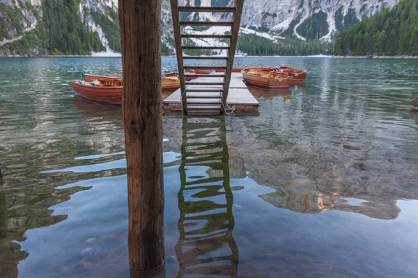 Barcos a remo atracados sob uma escada de madeira no lago Braies — Fotografia de Stock