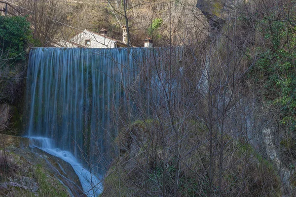 Vodopád v údolí se starobylým domem v pozadí — Stock fotografie