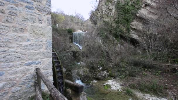 Όμορφος αρχαίος νερόμυλος σε ένα ποτάμι. Στο βάθος ένας καταρράκτης — Αρχείο Βίντεο