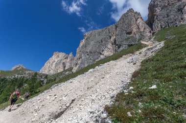 Dolomite duvarının dibinde yürüyen tanınmayan insanlar.