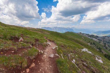 Tepe boyunca uzanan bir çayırda güzel bir Dolomite manzarası var.