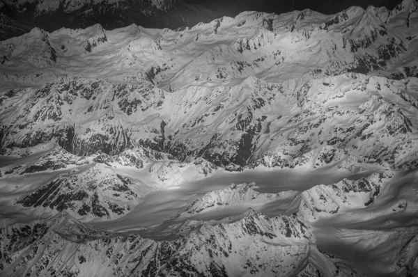 Black and white effect of snow-capped peaks of the Alps seen from the plane