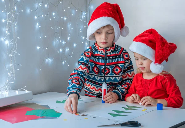 Дети клеят рождественские открытки для друзей. — стоковое фото