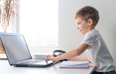 Küçük çocuk çevrimiçi ders veriyor. Online eğitim. Anaokulu çocuğu dizüstü bilgisayar kullanıyor..