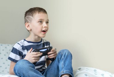 Evinde video oyunu oynayan hevesli küçük bir çocuk..