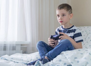 Oyun sahası olan küçük çocuk pencerenin yanında oyun oynuyor.