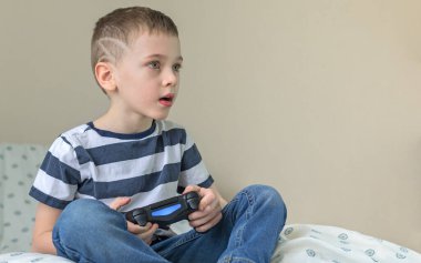 Evinde video oyunu oynayan hevesli küçük bir çocuk..