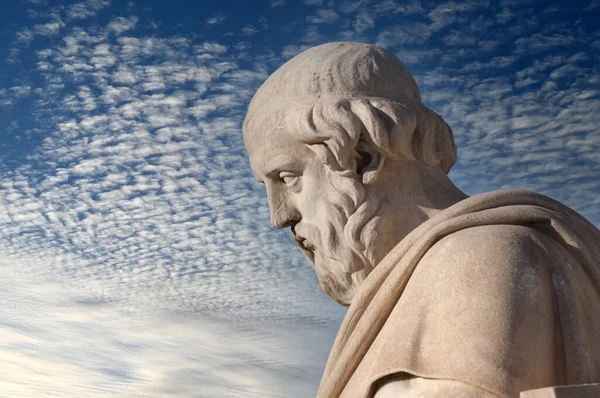 classic statue of greek philosopher Plato close up under blue sky with clouds