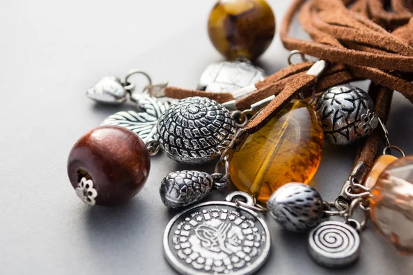 Primer plano de los encantos de metal y perlas de madera en gris —  Fotos de Stock