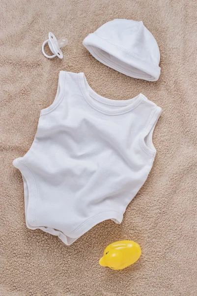 软毛巾上的婴儿衣服和奶嘴 — 图库照片