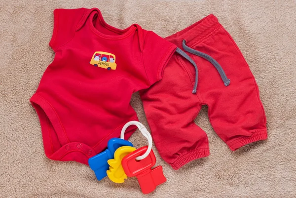Singola tuta da bambino rossa con chiavi giocattolo in plastica — Foto Stock