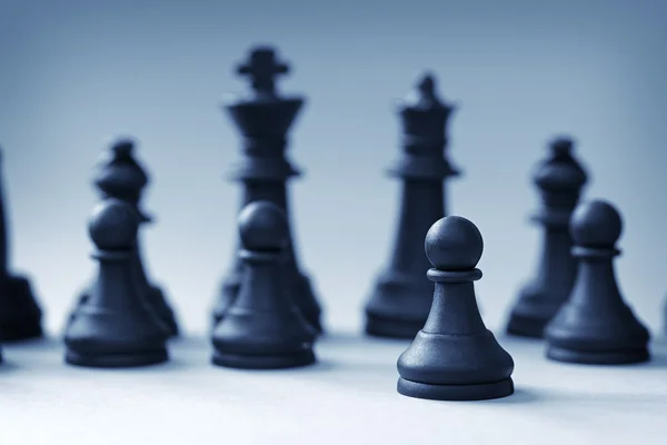 Close-up of black chess king and queen with pawns — Stock Photo, Image