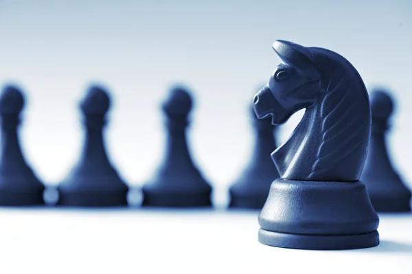 黒のチェスの駒と明るい青の背景の馬 — ストック写真