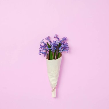 El işi kağıdına sarılı küçük bir buket mavi çiçek - Tazelik ve hediye - Pastel renkler ve modern konsept